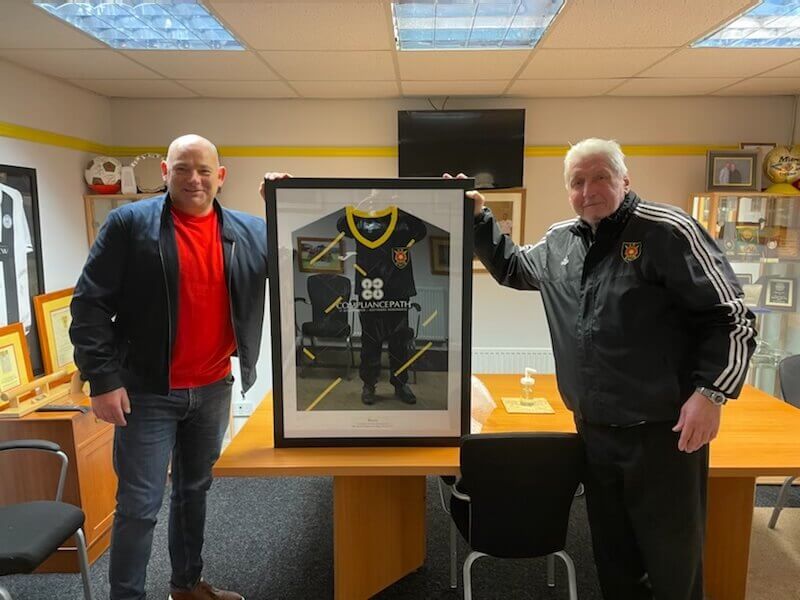 photo of Terry Gillooly accepting a signed player strip from the chairman of Albion Rovers FC